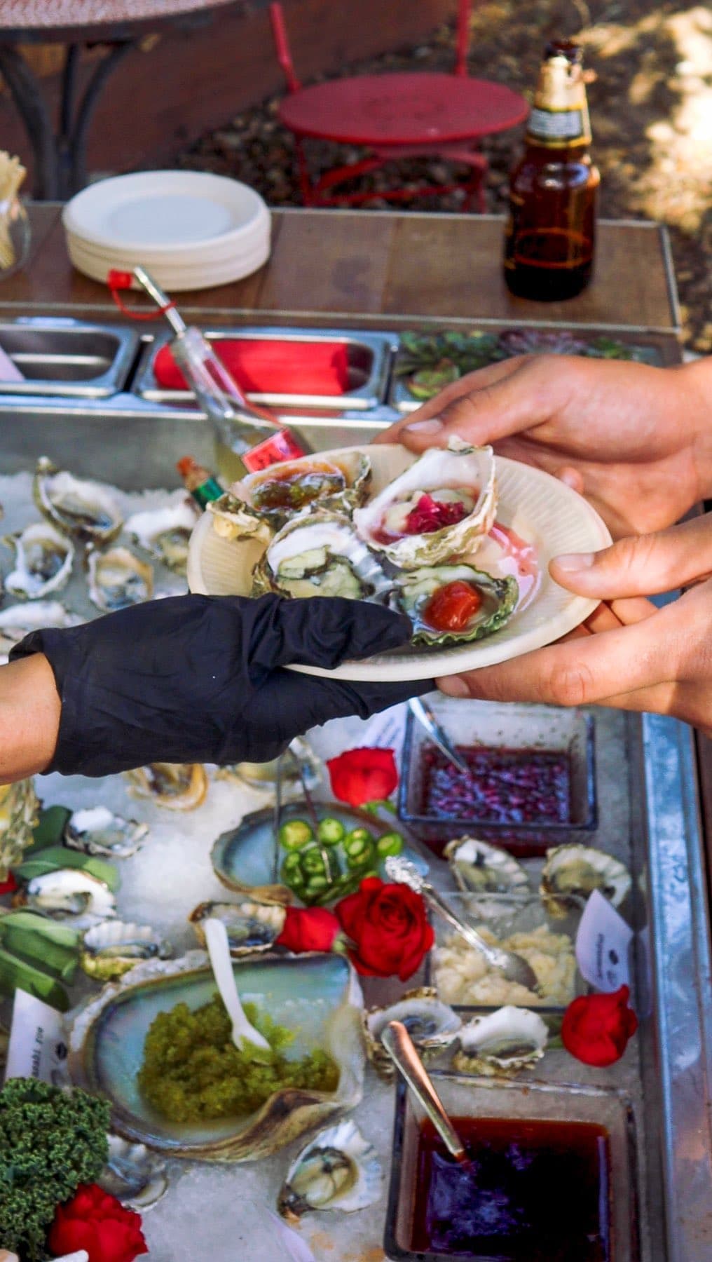 Guests reaching for dressed oysters at the raw bar