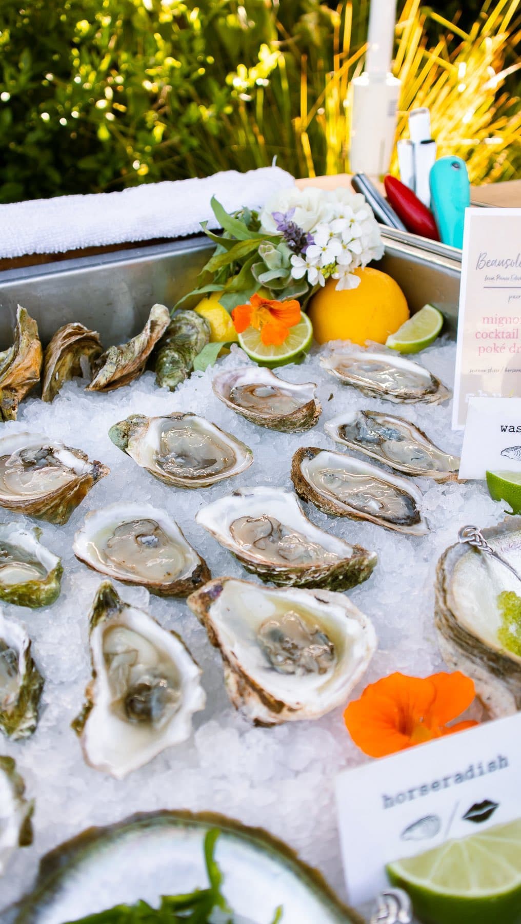 Oysters on ice with flowers and a hand-lettered sign